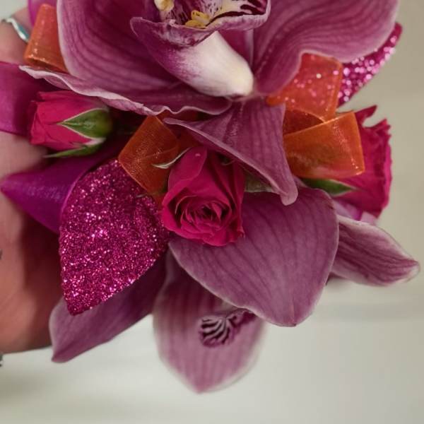 Pink orchid and rose corsage with orange ribbon accents