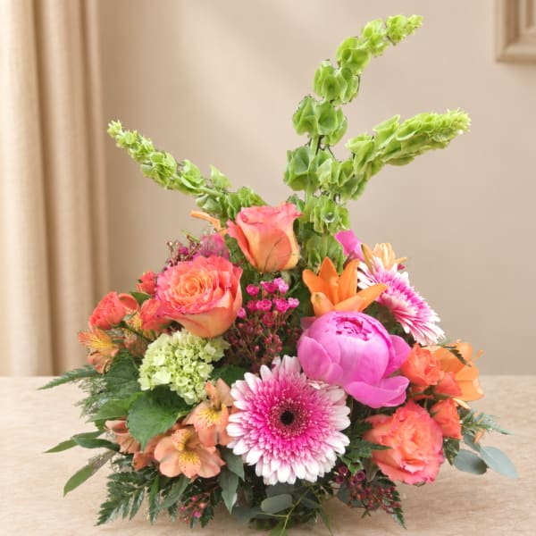 Colorful mixed bouquet with roses, lilies, and gerbera daisies in a low arrangement