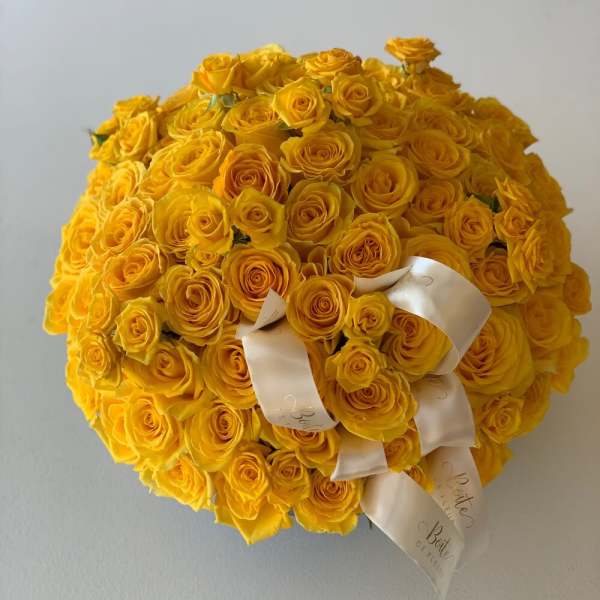 Large round bouquet of yellow roses with white ribbon