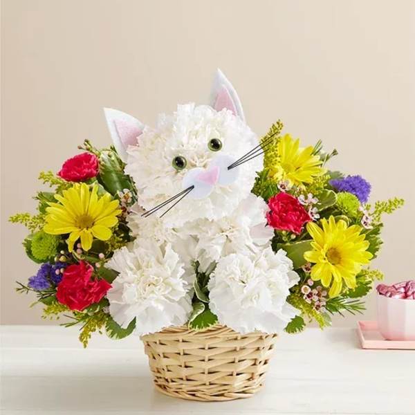 White cat-shaped flower basket with colorful blooms and a pink gift box