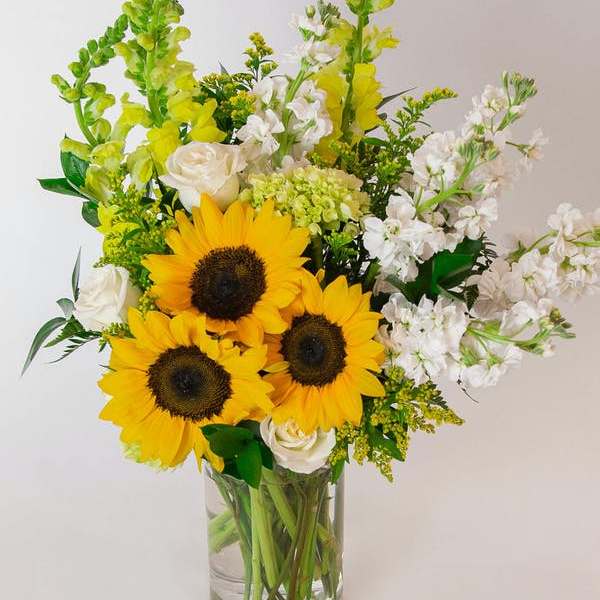 Sunflowers and white roses in a clear glass vase