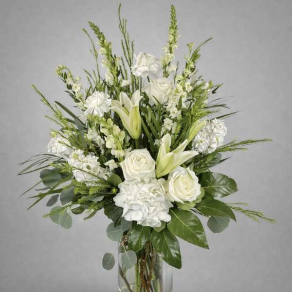 White roses and lilies in a clear glass vase