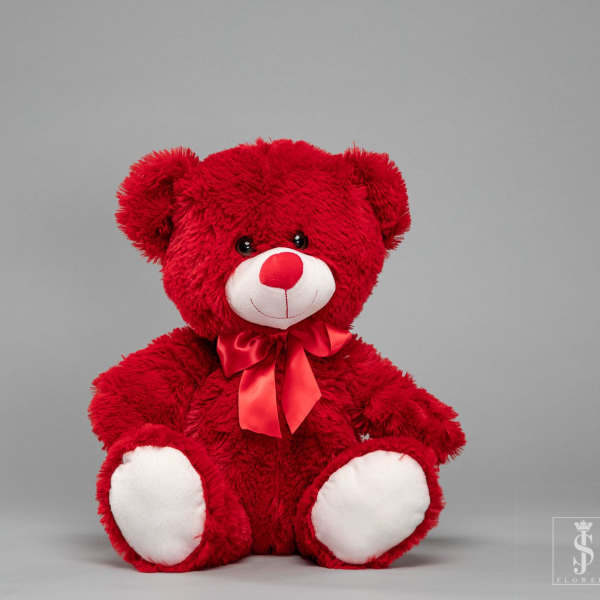 Red teddy bear with a satin bow on a gray background