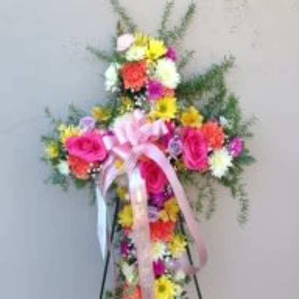 Standing floral spray with pink roses and multicolored daisies on an easel