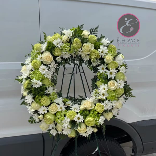 Large floral wreath of white and green flowers on a stand