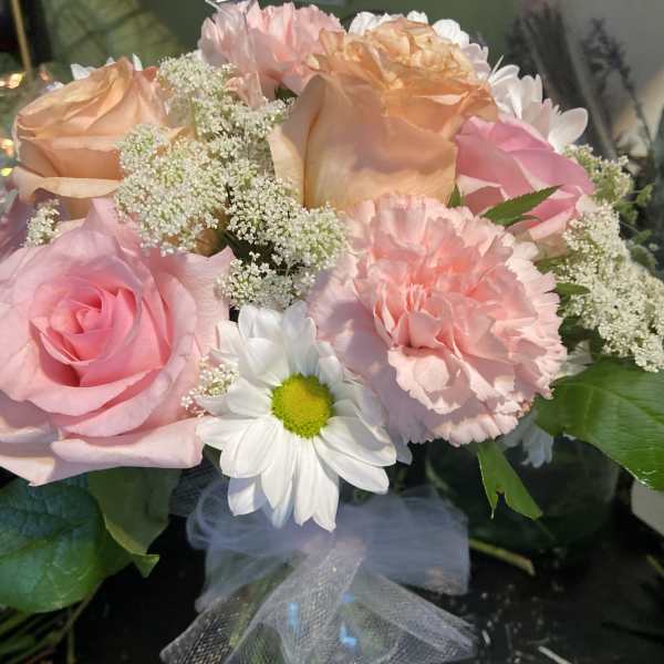 Bouquet of pink and peach roses with white daisies and carnations