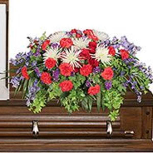 Colorful floral arrangement on a casket with red, white, and purple flowers