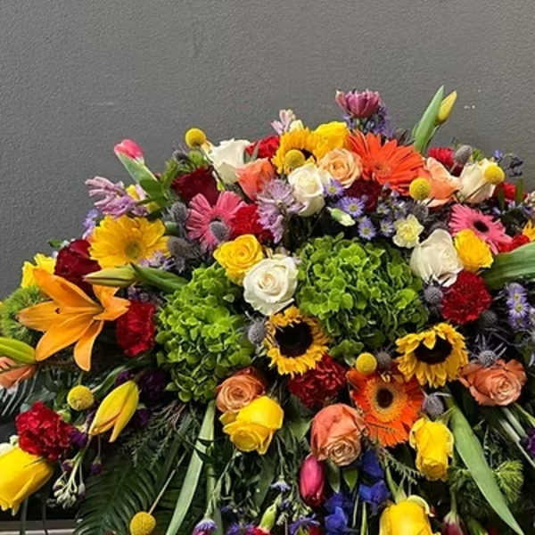 Large colorful floral arrangement with roses, lilies, and gerbera daisies