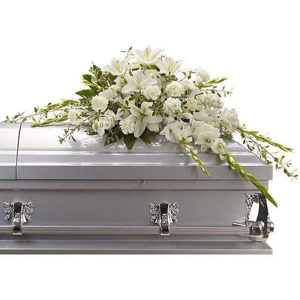 White floral spray arranged on a silver casket