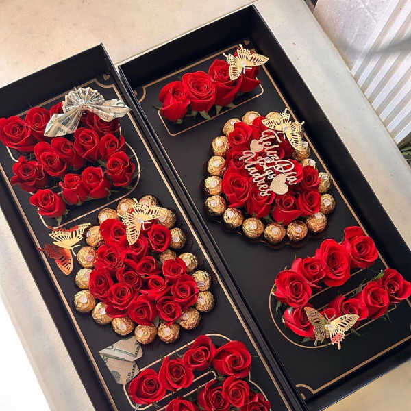 Black gift boxes with red roses, chocolates, and folded cash bows