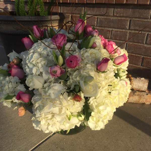Bouquet of white hydrangeas and pink roses in a low container