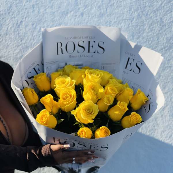 Bouquet of yellow roses wrapped in printed paper