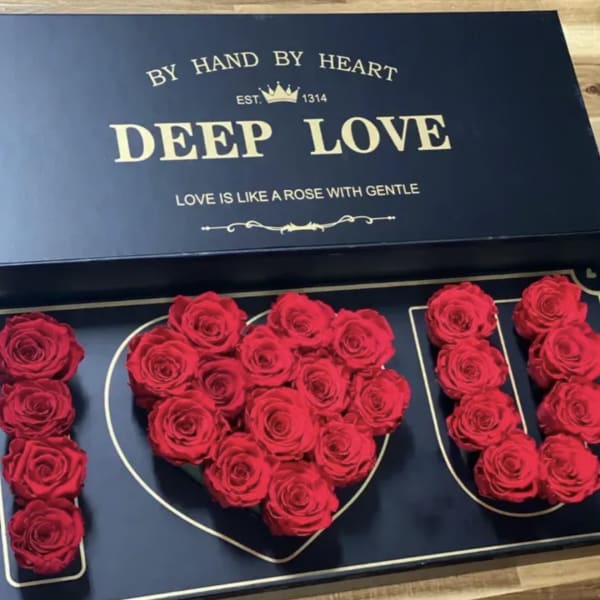 Red roses arranged in a heart-shaped box with matching rose letters