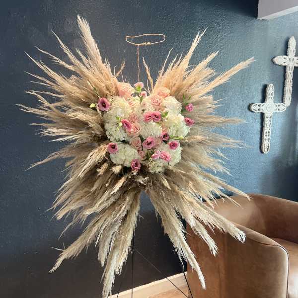Large floral spray with pink and white blooms and pampas grass on a stand