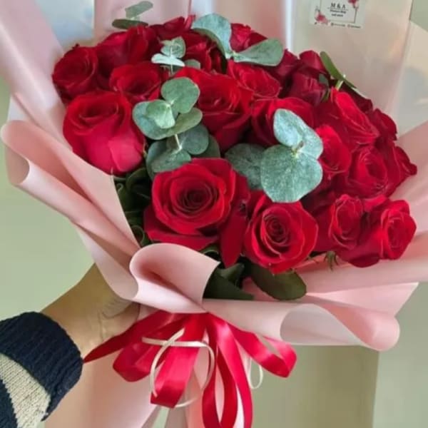 Bouquet of red roses with eucalyptus wrapped in pink paper