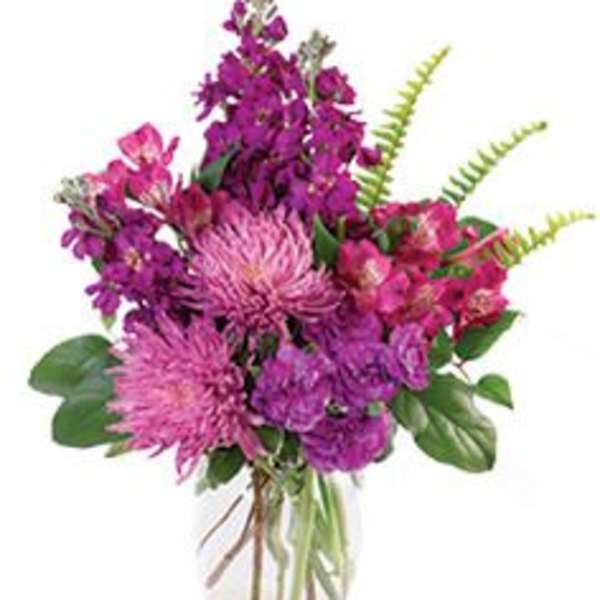 Purple and pink mixed bouquet in a clear glass vase