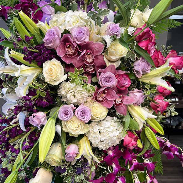 Large bouquet of roses, lilies, orchids, and hydrangeas in pink, purple, and white