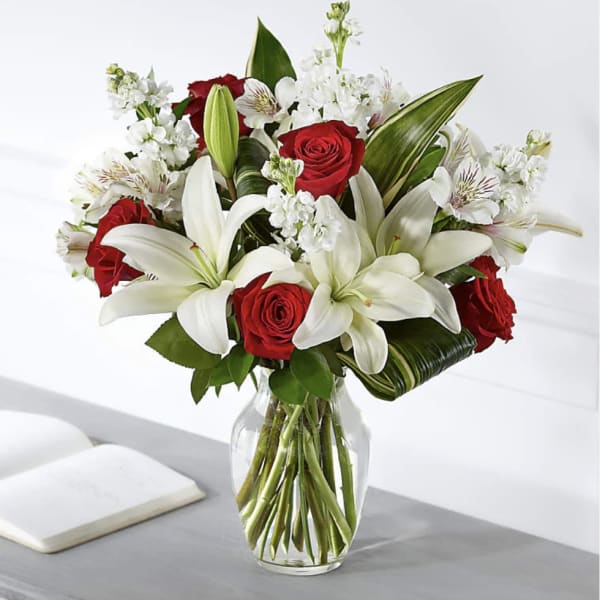 Bouquet of red roses and white lilies in a clear glass vase