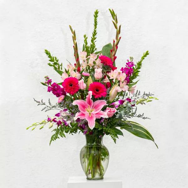 Pink and magenta mixed flower arrangement in a clear glass vase