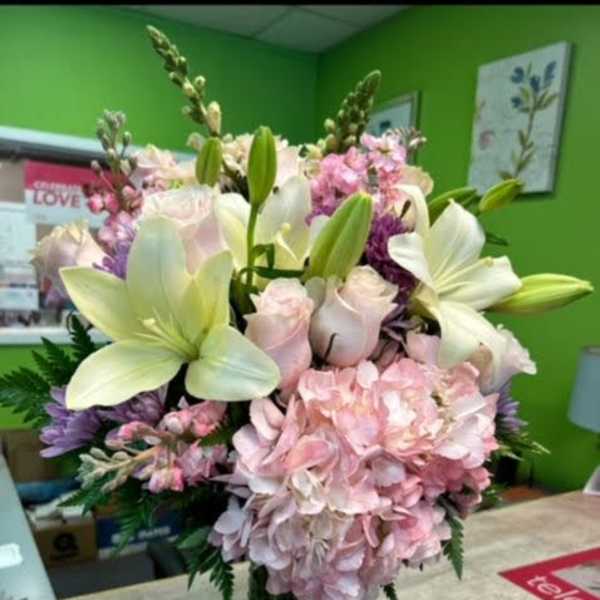 Pink and white floral arrangement in a glass vase