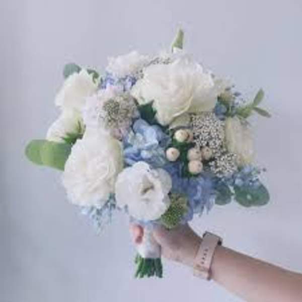 Handheld bouquet of white and pale blue flowers
