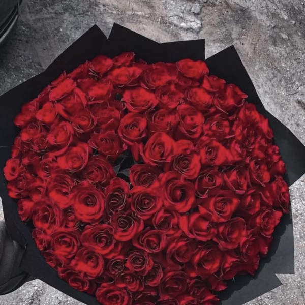 Large bouquet of red roses wrapped in black paper