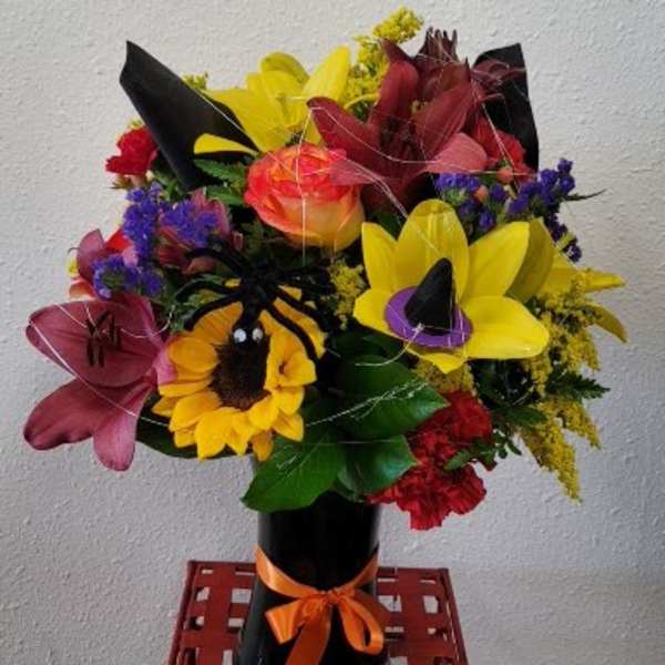 Colorful bouquet with sunflowers and lilies in a black vase
