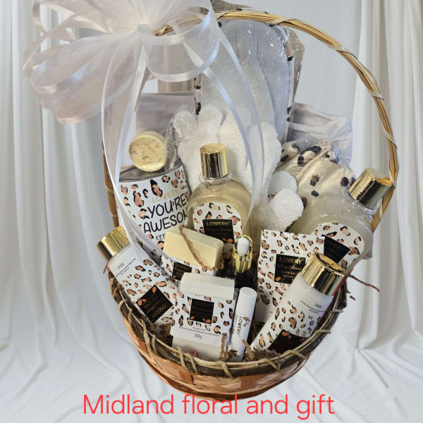 Gift basket with bath and body products tied with a large white bow