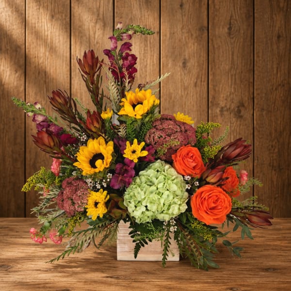 Mixed bouquet in a white wooden box with sunflowers and orange roses