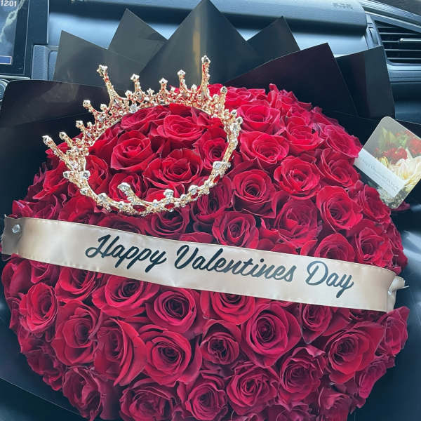 Heart-shaped bouquet of red roses with a jeweled crown and Valentine ribbon