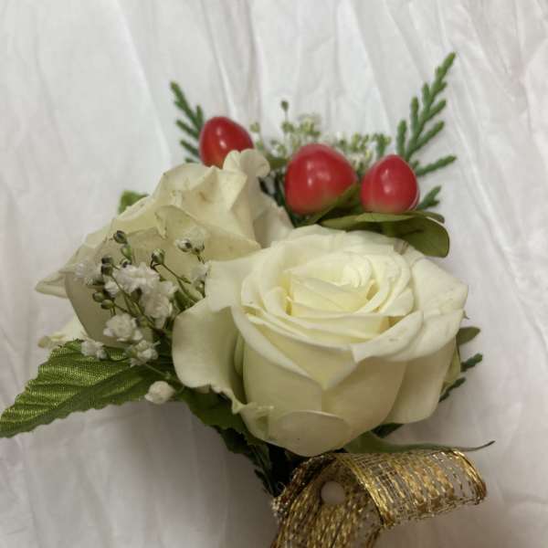 Small bouquet of white roses with red berry accents and gold ribbon