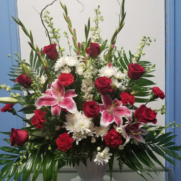 Large vase arrangement with red roses, pink lilies, and white chrysanthemums