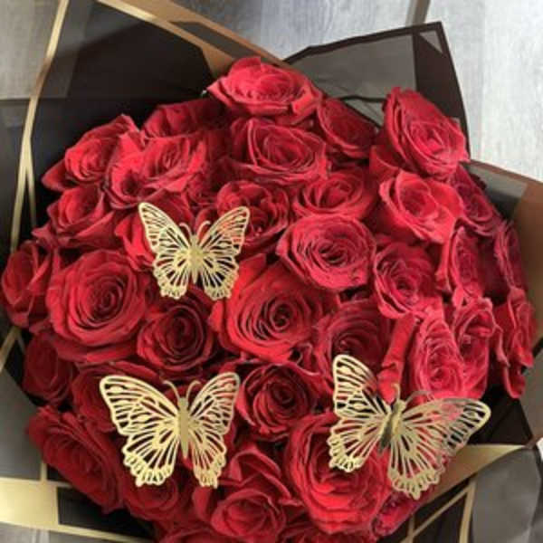 Bouquet of red roses with gold butterfly accents in black wrapping