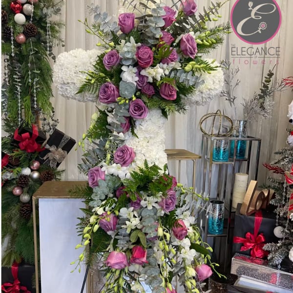 Tall floral cross with purple roses and white blooms