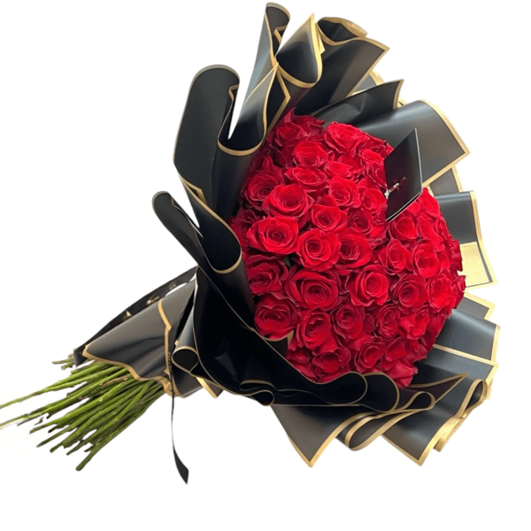 Large bouquet of tightly packed red roses wrapped in ruffled black and gold paper