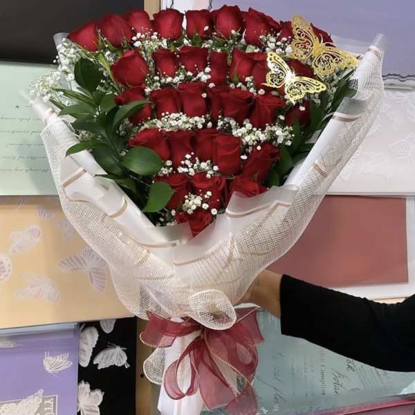 Bouquet of red roses with baby's breath and butterfly accents