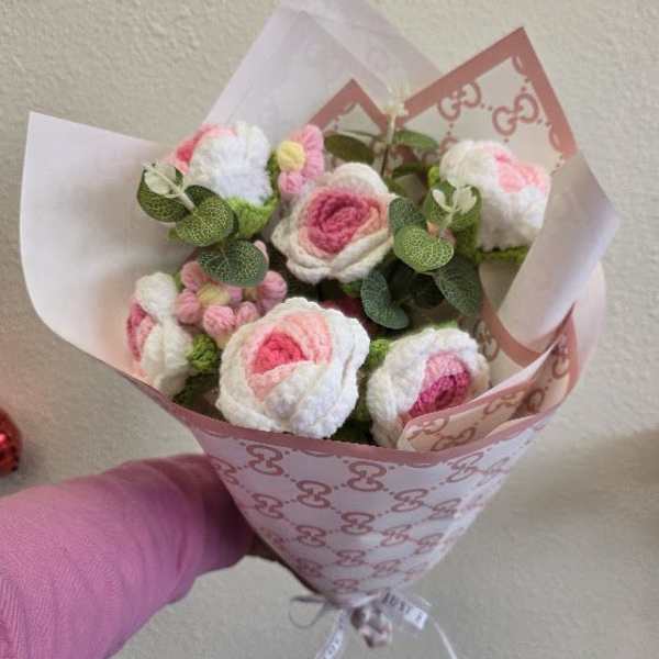 Small bouquet of pink and white flowers wrapped in patterned paper