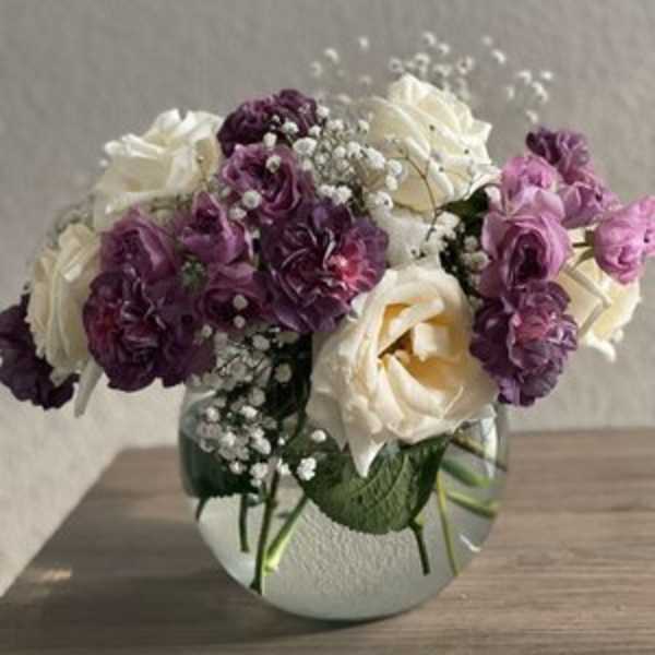 Bouquet of white and purple roses in a glass vase