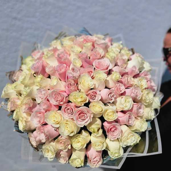 Large bouquet of pale pink and cream roses wrapped in clear paper