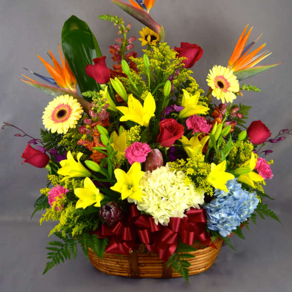 Colorful tropical flower basket with lilies, roses, and gerbera daisies