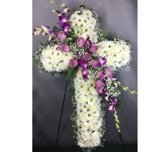 White and purple floral cross on a stand