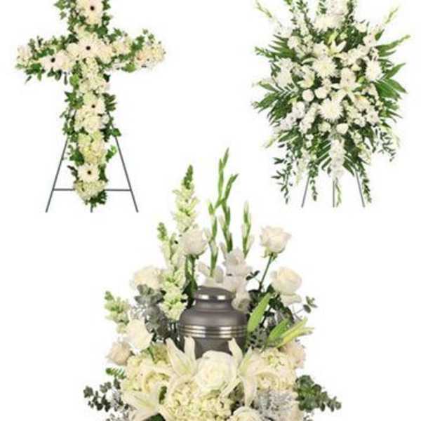 White funeral floral set with a cross, standing spray, and urn arrangement