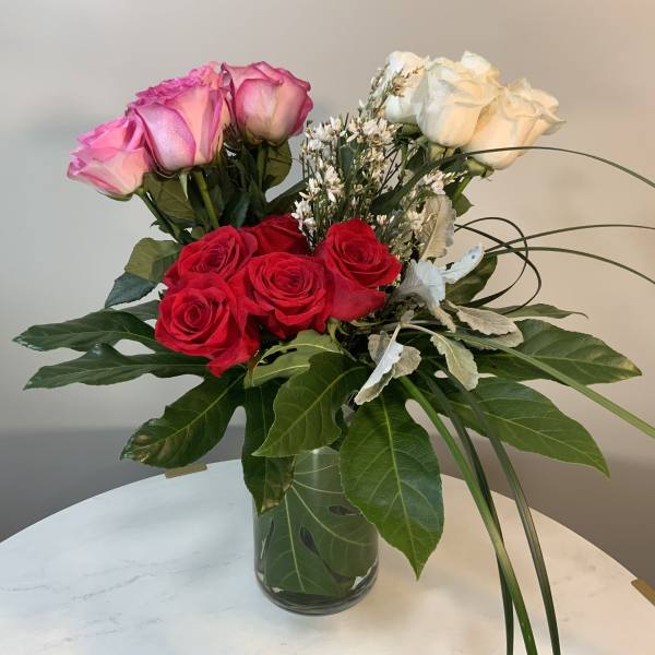 Bouquet of pink, red, and white roses in a glass vase
