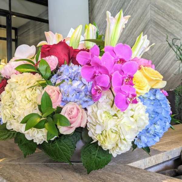 Large bouquet of hydrangeas, roses, lilies, and orchids in bright colors