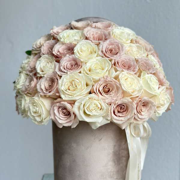 Round bouquet of pale pink and cream roses in a velvet hatbox