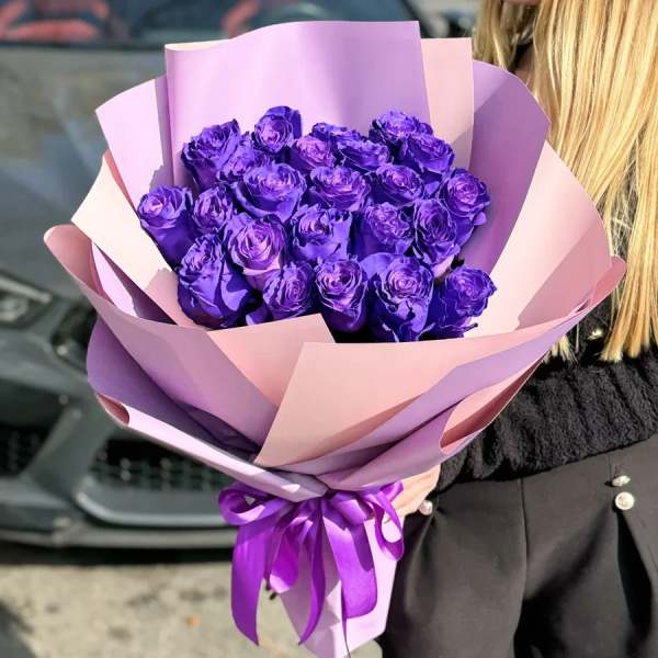 Bouquet of purple roses wrapped in pink and lavender paper