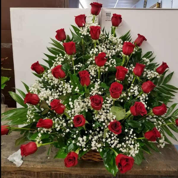 Basket arrangement of red roses with white baby's breath