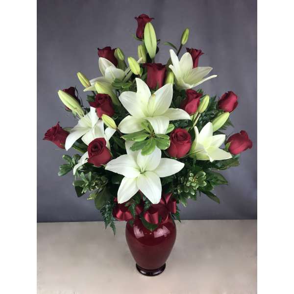 Red roses and white lilies in a burgundy vase