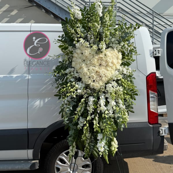 Large white floral standing spray with roses and cascading blooms