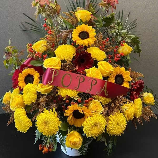 Large yellow floral arrangement with a red "PAPA" ribbon